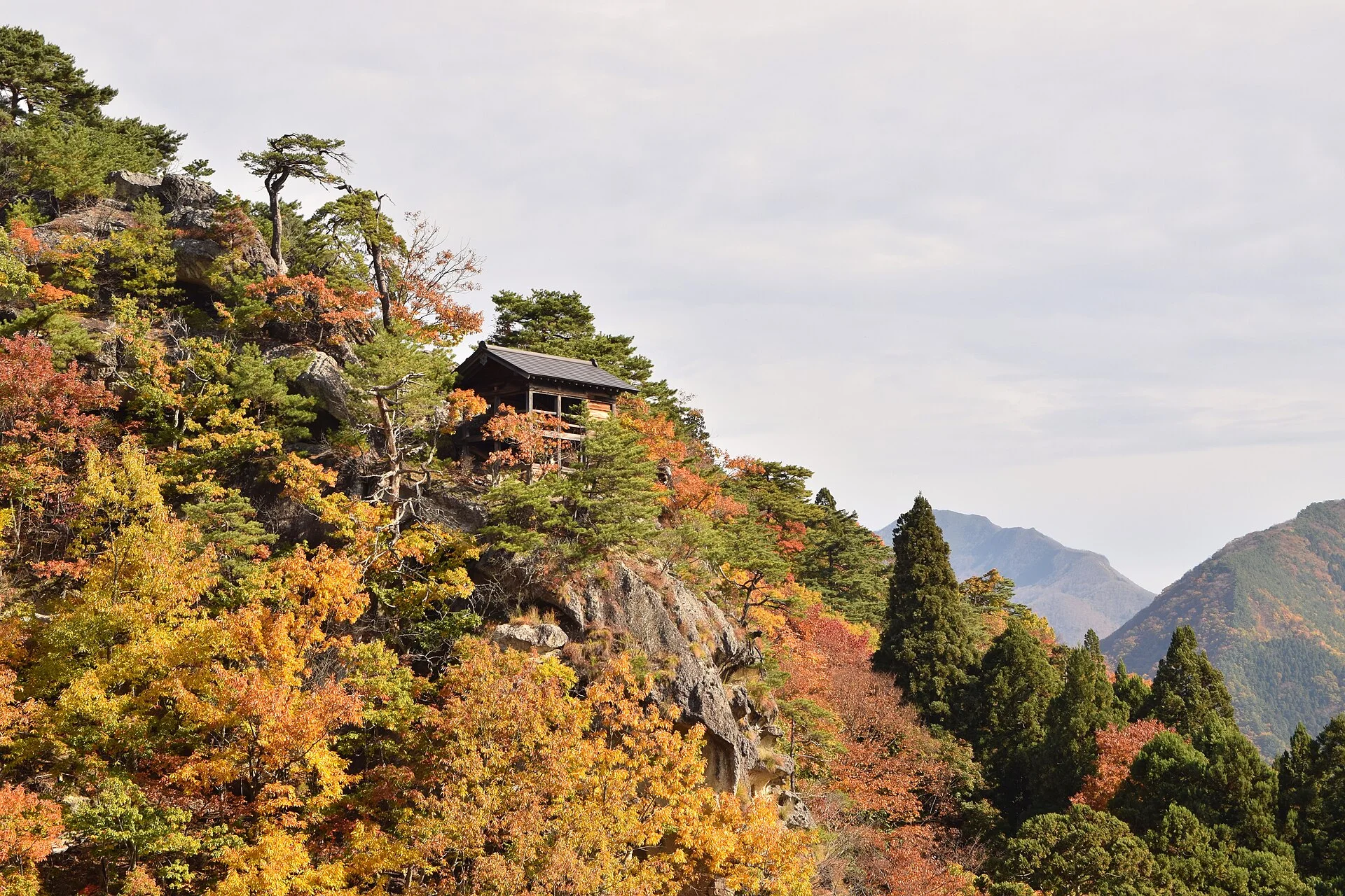 Upper Yamadera temple buildings and autumn foliage beyond Niomon