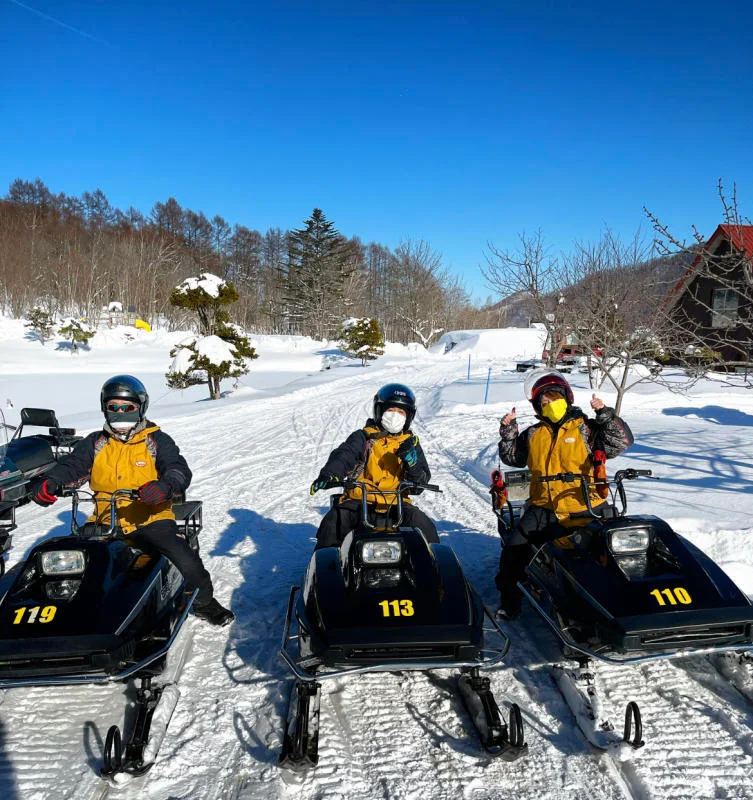 Wonderland Sapporo snowmobile riders preparing for a mountain route; a 60- or 90-minute mountain course is a different product from a short city-accessible taster.