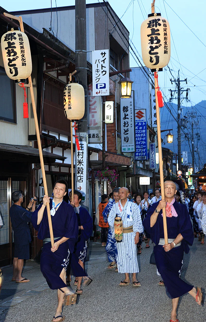 Yukata-clad dancers joining a Gujo Odori street circle at night