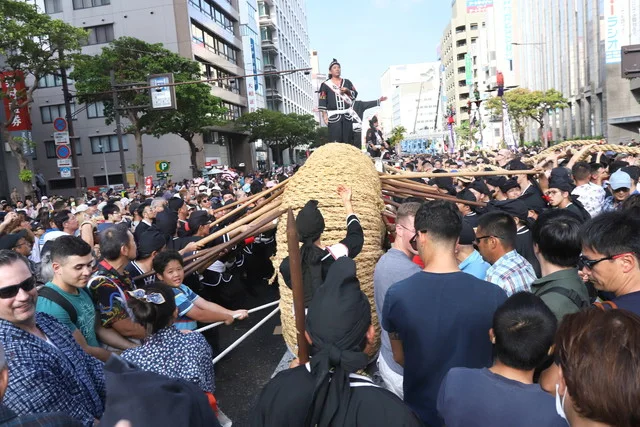 Participants gripping hand ropes during the Naha Great Tug-of-War