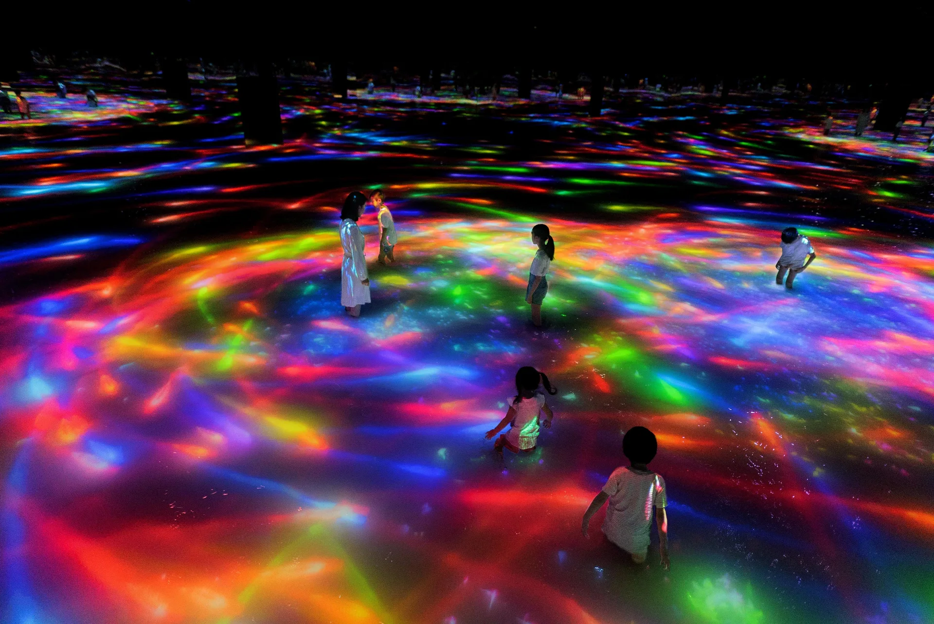 Visitors wading through an interactive water artwork at teamLab Planets Tokyo