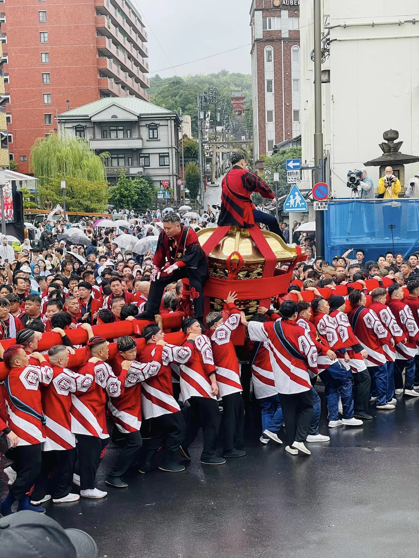 Dogo Autumn Festival mikoshi procession continuing through Matsuyama streets in wet weather