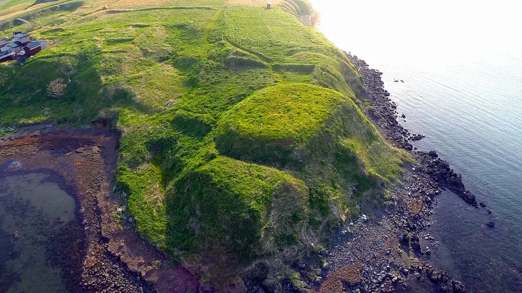 Aerial view of the Onnemoto Ainu fortified enclosure showing ditches, raised earth and two flat areas on the headland