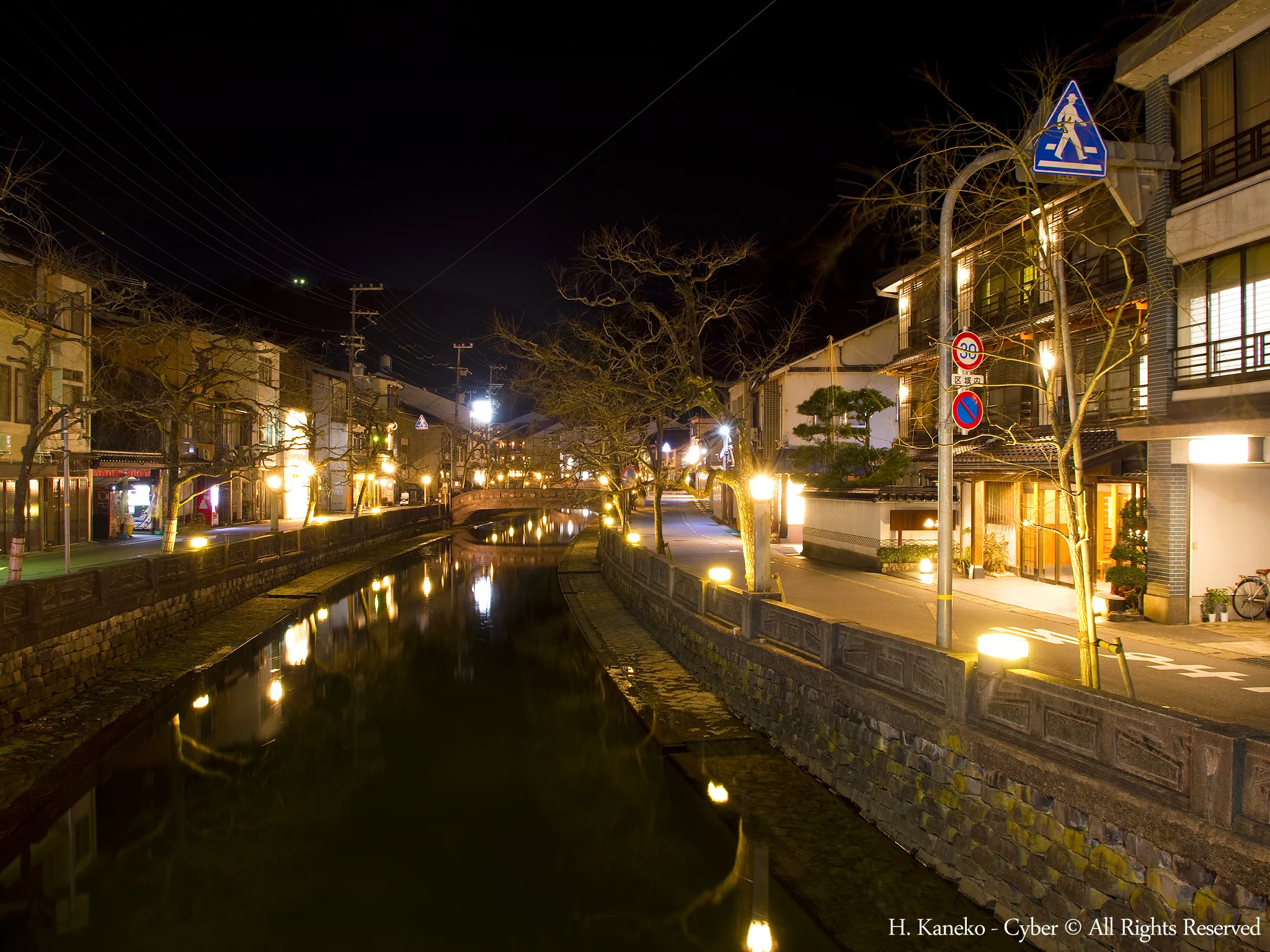 Kinosaki Onsen streets at night, when guests walk between ryokans and public bathhouses in yukata