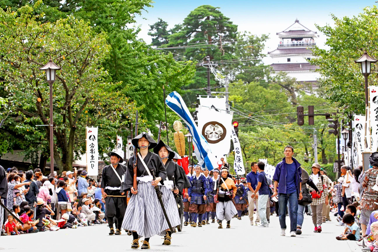 Aizu Festival 2026 historical procession with Tsurugajo Castle in the background
