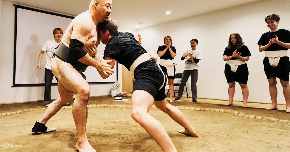 Guest taking part in an interactive Osaka sumo experience with a retired wrestler