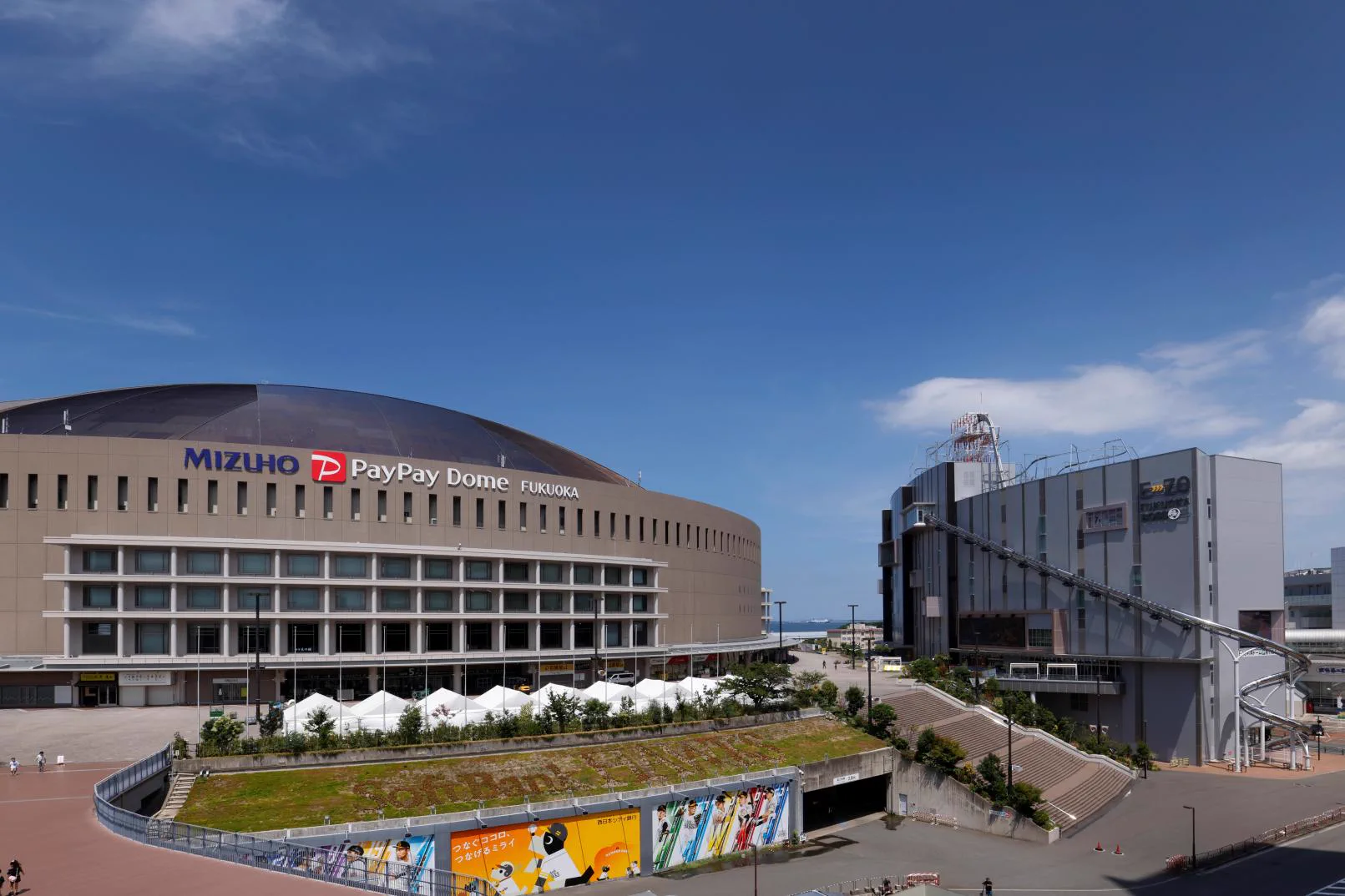 BOSS E・ZO FUKUOKA beside Mizuho PayPay Dome, with the sube-ZO tube visible on the building exterior.