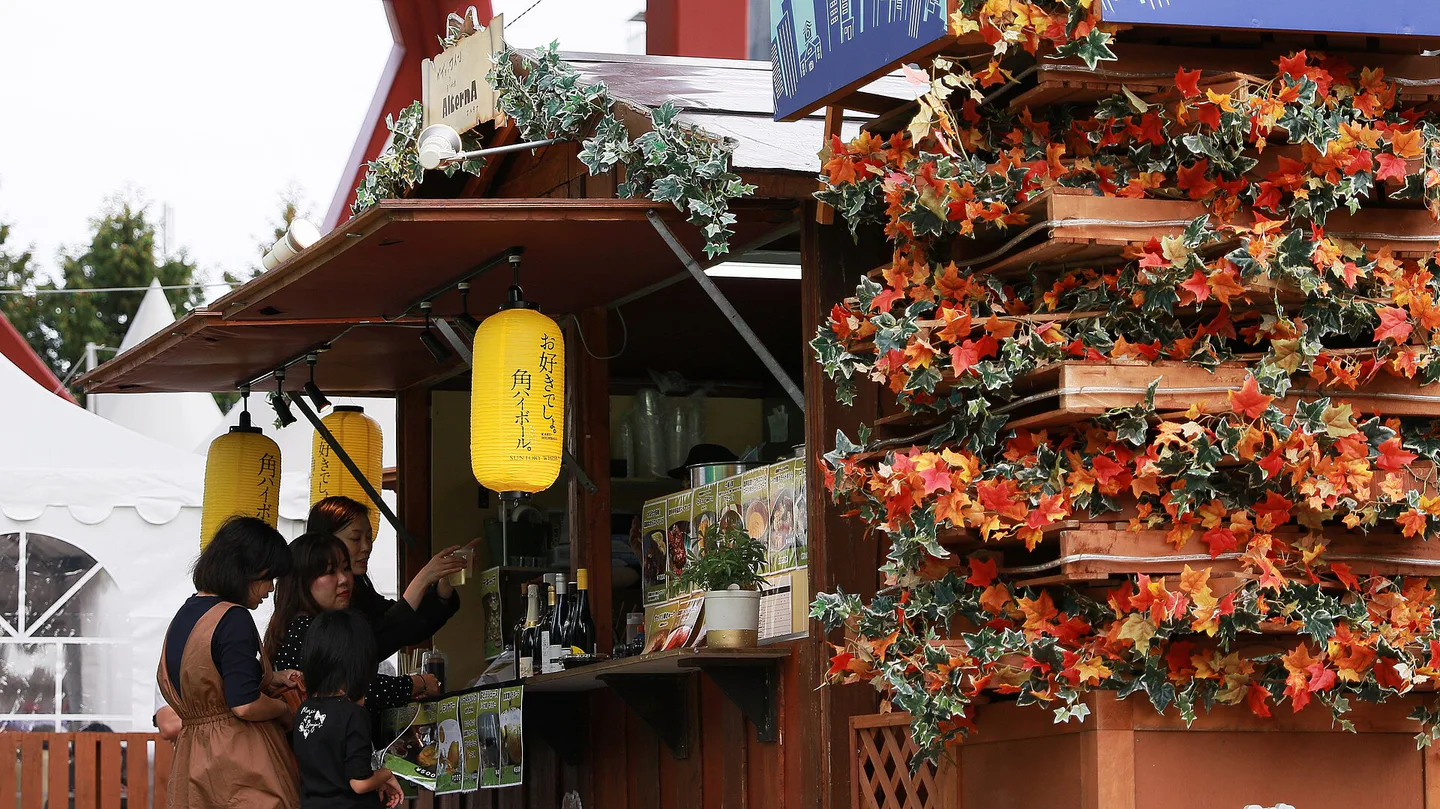 Outdoor tables, food stalls and evening crowds at Sapporo Autumn Fest in Odori Park