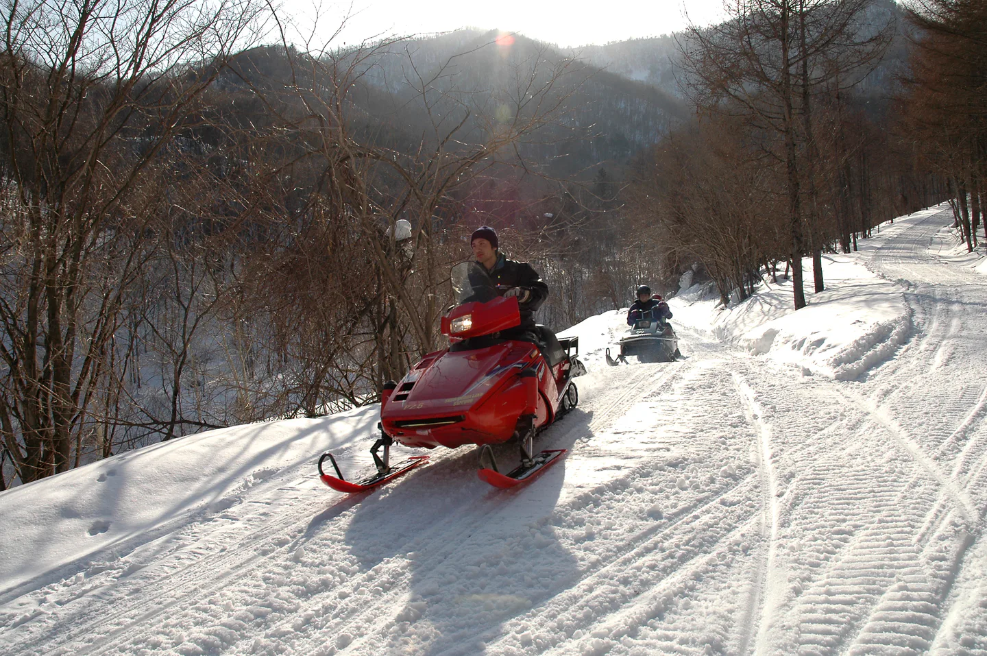 Sapporo Snowmobile Land mountain trail in winter, comparing 30-, 60- and 90-minute snowmobile experiences.