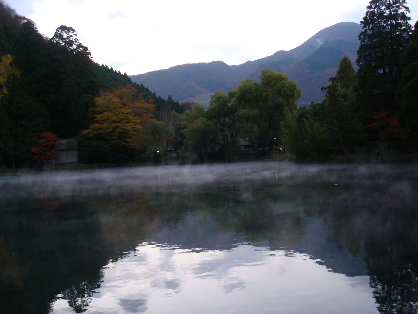 Morning vapour above Lake Kinrin with autumn trees around the water